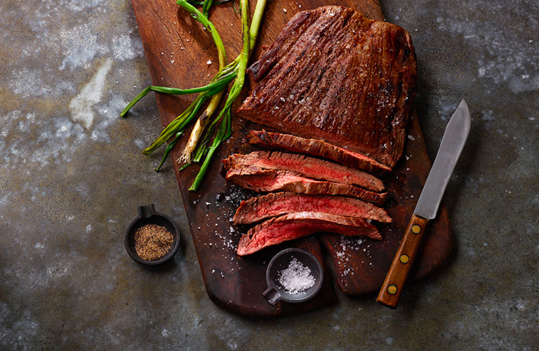 Grilled steak with olive oil charred scallions